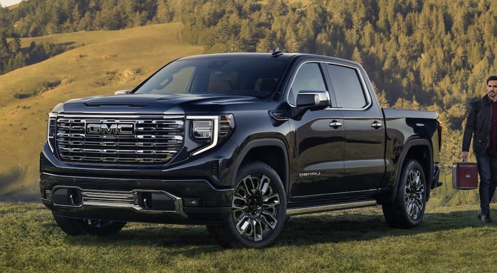 A black 2023 GMC Sierra 1500 Denali is shown parked off-road by a GMC dealer near Brighton.