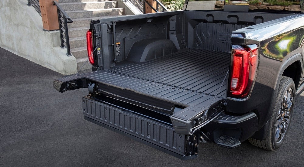 A close-up shows the tailgate on a black 2025 GMC Sierra 1500 Denali Ultimate.