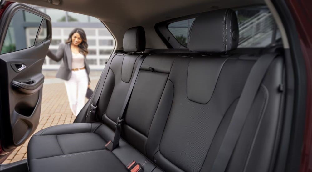 A person is shown opening the door of a 2024 Buick Encore GX Avenir.