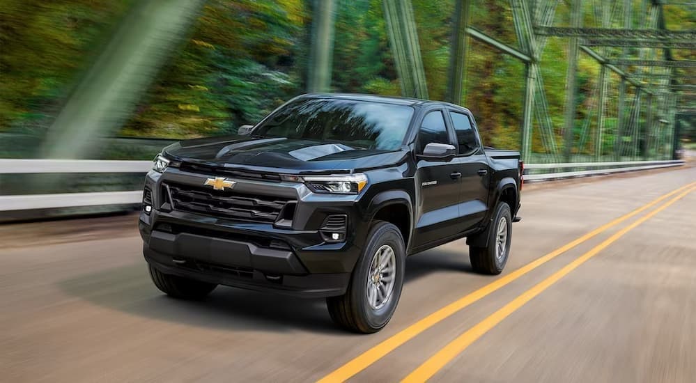 A black 2023 Chevy Colorado driving on a bridge.