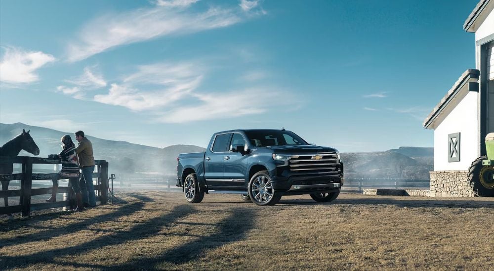 A black 2024 Chevy Silverado 1500 High Country parked at a ranch.