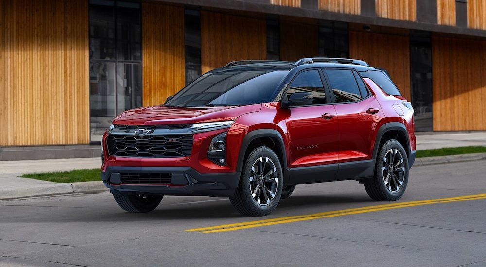 A red 2025 Chevy Equinox is shown driving from a Chevy dealer near Ypsilanti.