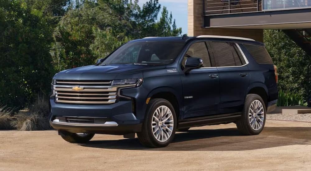 A blue 2023 Chevy Tahoe is shown parked near a building.