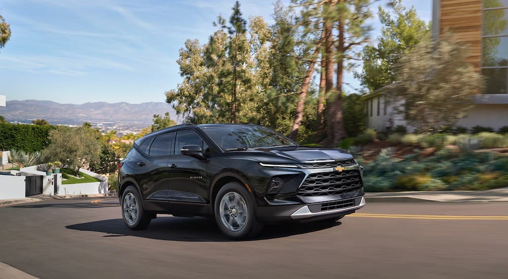 A black 2025 Chevy Blazer driving through a suburb.