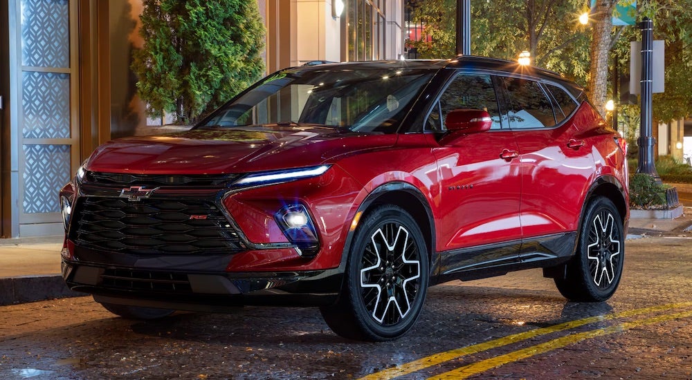 A red 2024 Chevy Blazer RS driving in a city.