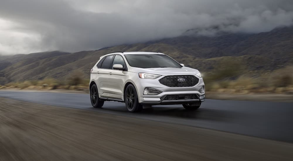 A white 2024 Ford Edge driving to a Chevy dealer near Saline.