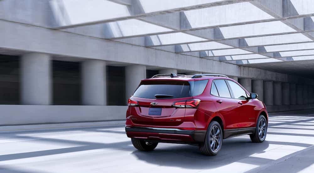 A red 2024 Chevy Equinox RS is shown from the rear at an angle.