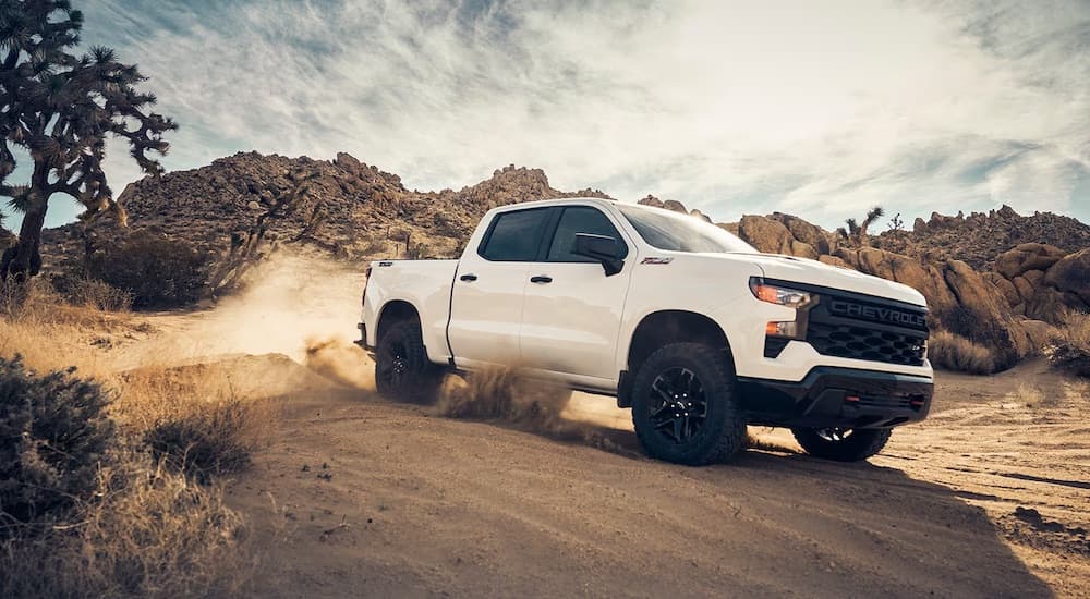 A white 2024 Chevy Silverado 1500 for sale is shown from the front at an angle.