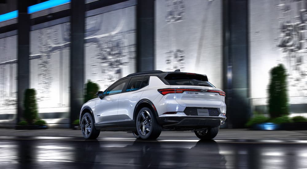 A white 2024 Chevy Equinox EV is shown from the rear at an angle.