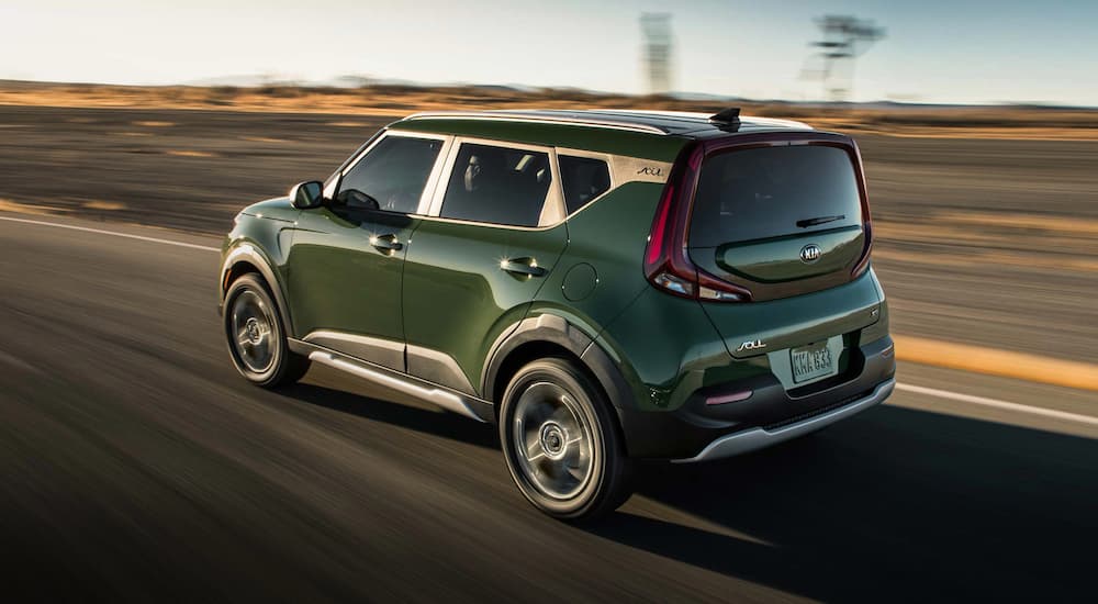 Green 2021 Kia Soul driving to a used car dealer.