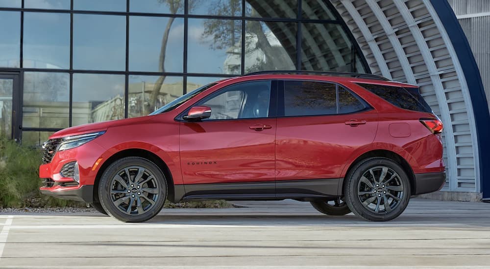 A red 2023 Chevy Equinox RS parked in a city.