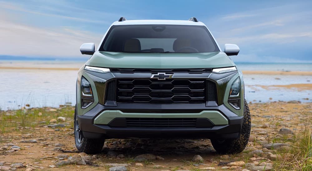 Front angle view of a green 2025 Chevy Equinox parked off-road.