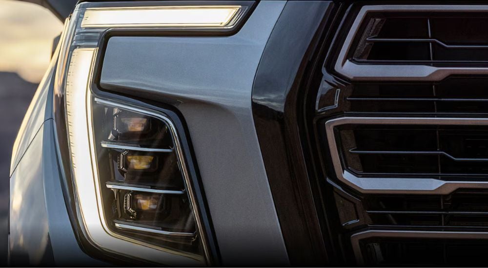 The front end of a grey 2025 GMC Yukon is shown in close-up after leaving a GMC dealer near Charlotte.