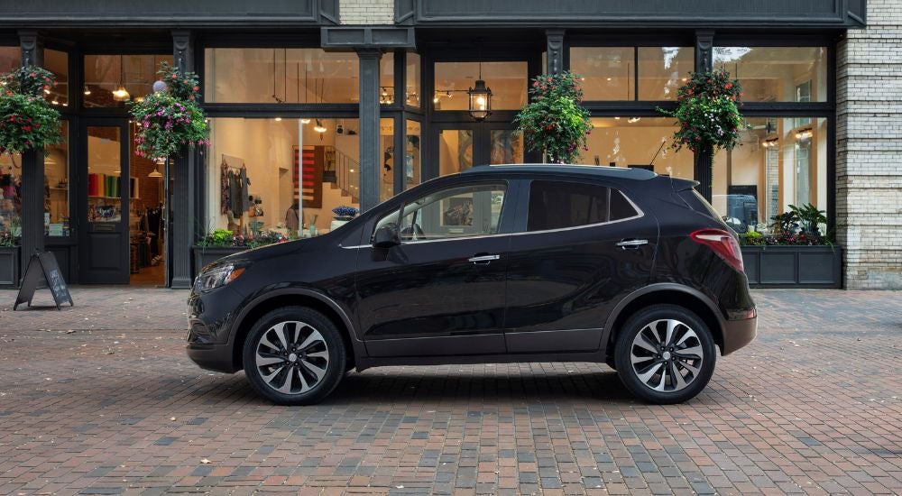 Black 2022 Buick Encore parked in front of a shop.