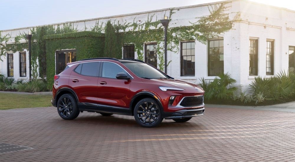 A red 2024 Buick Encore GX ST is shown parked by a Buick dealer.