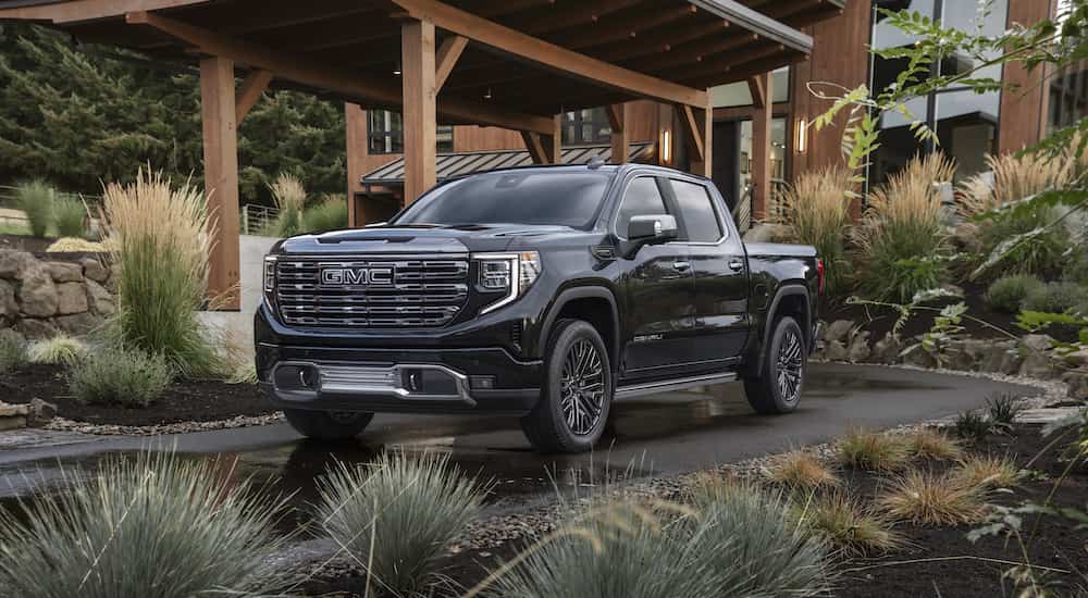 A black 2025 GMC Sierra 1500 Denali Ultimate parked near a GMC dealer in Lansing.
