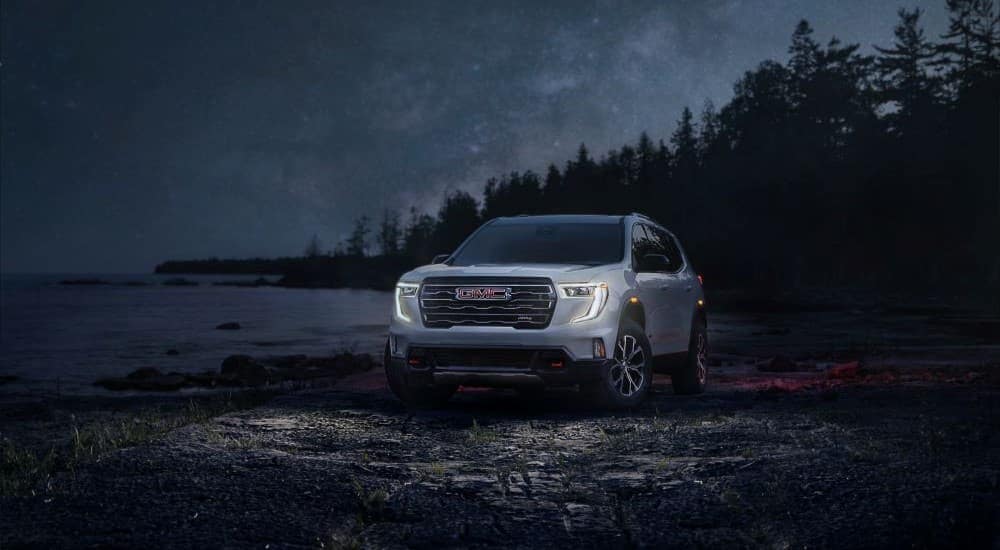 A front angle view of a silver 2024 GMC Acadia Denali angled left.
