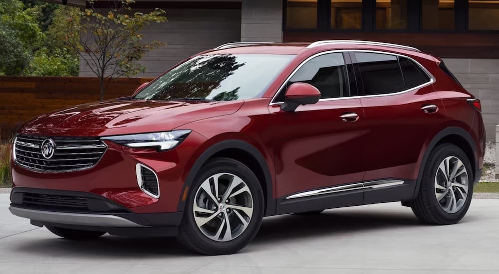 A red 2024 Buick Envision is shown parked by a Buick dealer near Farmington Hills.