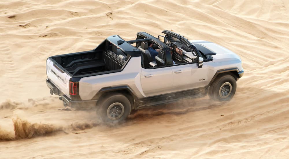 A white 2025 GMC Hummer EV is shown from the side after leaving a dealer that has EVs for sale.