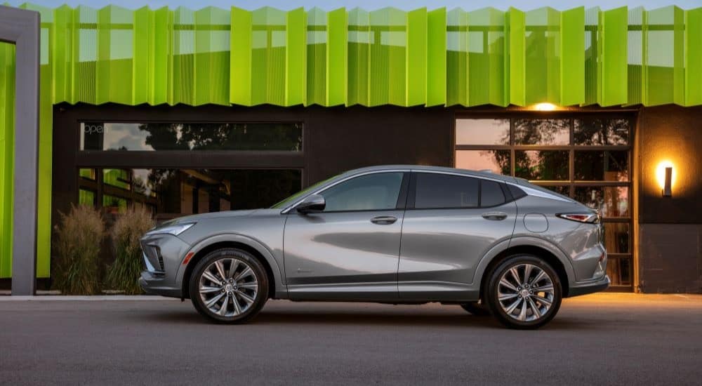 A silver 2024 Buick Envista Avenir is shown from the side parked in front of a shop.