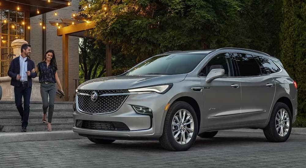 A silver 2024 Buick Enclave Avenir parked in a city.