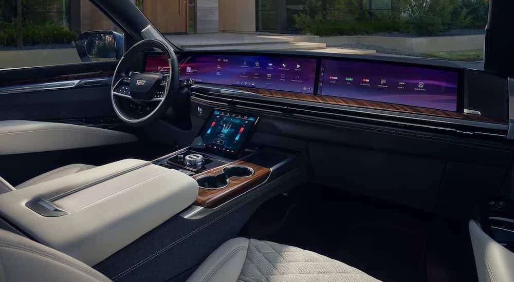 Steering wheel, front seats and dashboard in the black and white interior of a 2025 Cadillac Escalade.