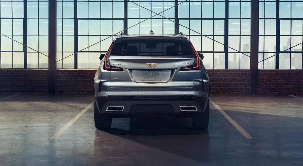 A silver 2024 Cadillac XT4 350T is shown from the rear parked in a warehouse.