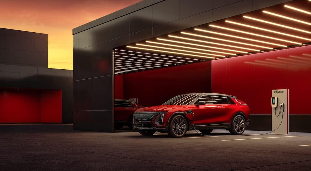 A red 2024 Cadillac LYRIQ is shown from the front at an angle while charging.