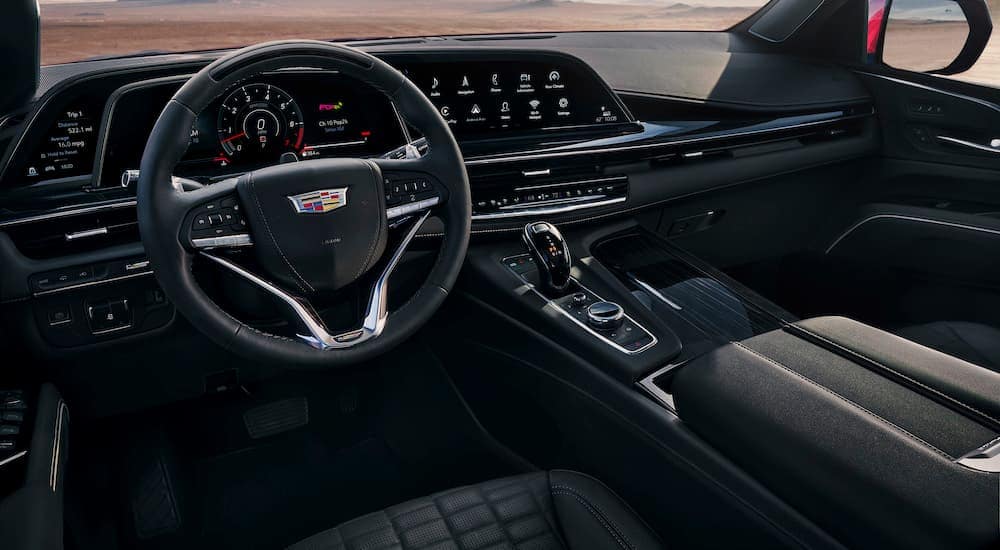 The black interior of a 2024 Cadillac Escalade V is shown from the driver's seat.