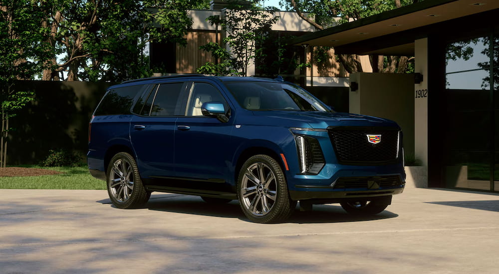 Blue 2027 Cadillac Escalade parked on a driveway.