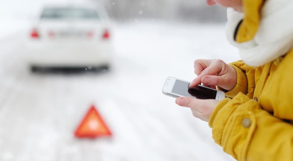 A person using a cellphone on a snowy day.