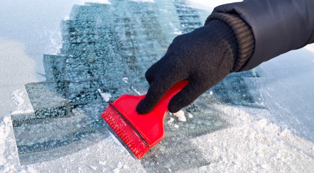 A person using a window scraper. 