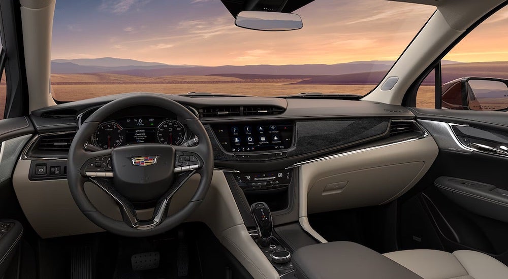 The tan interior of a 2024 Cadillac XT6 is shown from the driver's seat.
