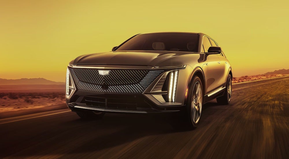 A black 2024 Cadillac LYRIQ driving from a Cadillac dealer near Dearborn.