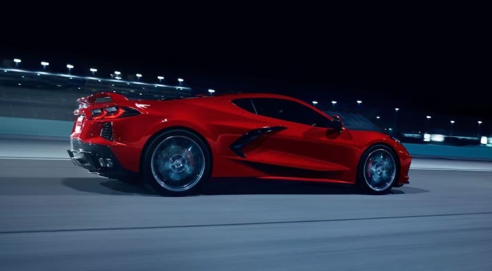 A red 2024 Chevy Corvette Stingray Z51 driving on a track at night.