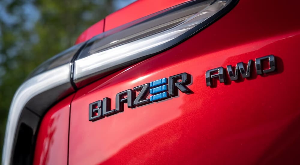 Close-up of the AWD badge on the rear of a red 2024 Chevy Blazer EV for sale.