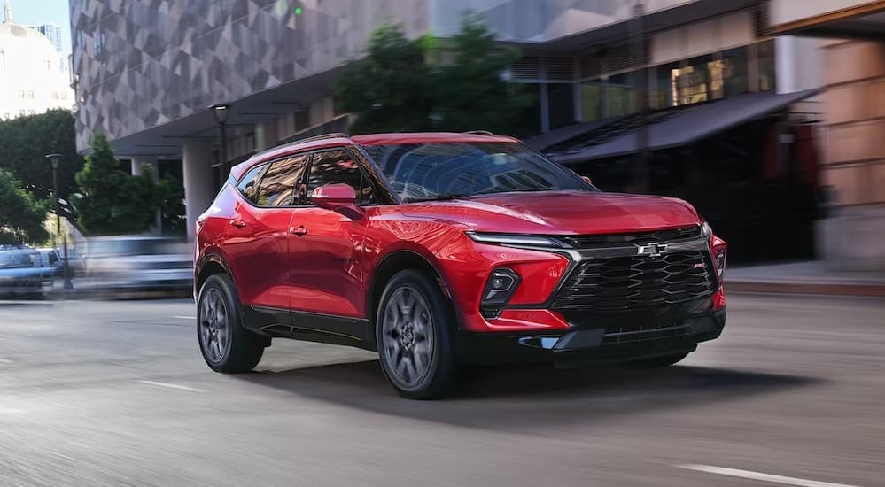 A red 2024 Chevy Blazer RS driving in a city.