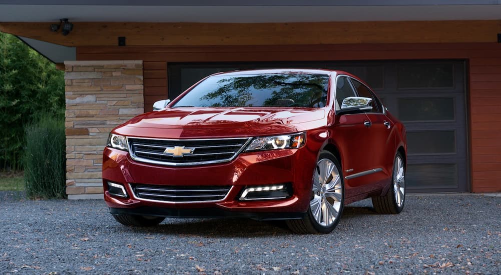 A red 2020 Chevy Impala parked on a driveway.