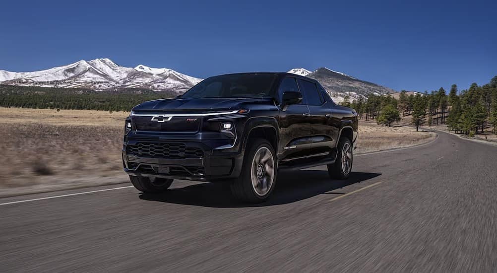 A black 2025 Chevy Silverado EV RDT driving on a highway.