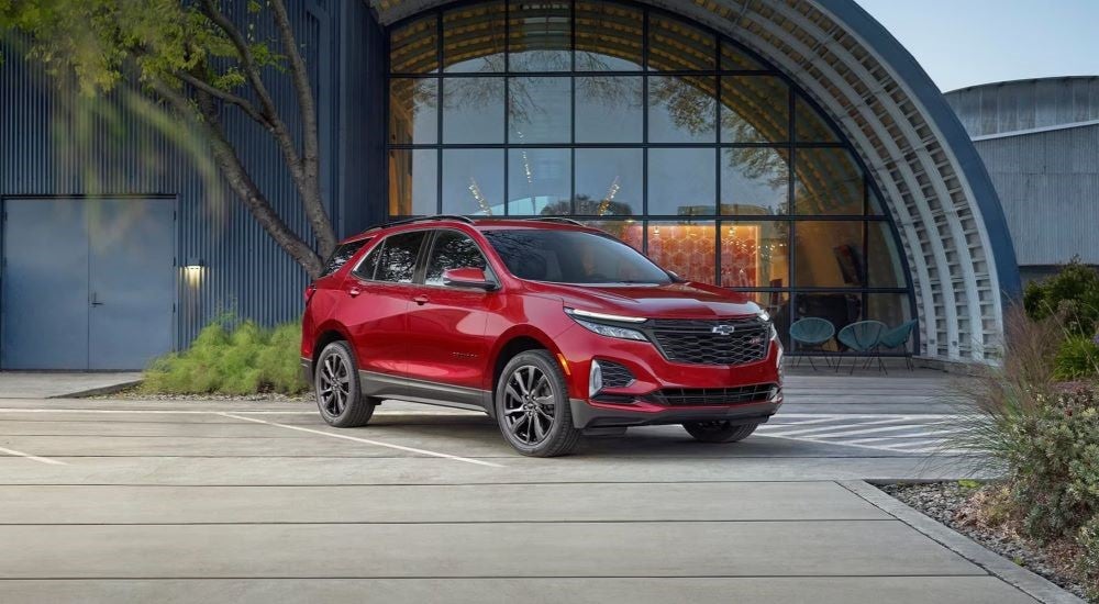 A red 2024 Chevy Equinox RS parked outside a building.