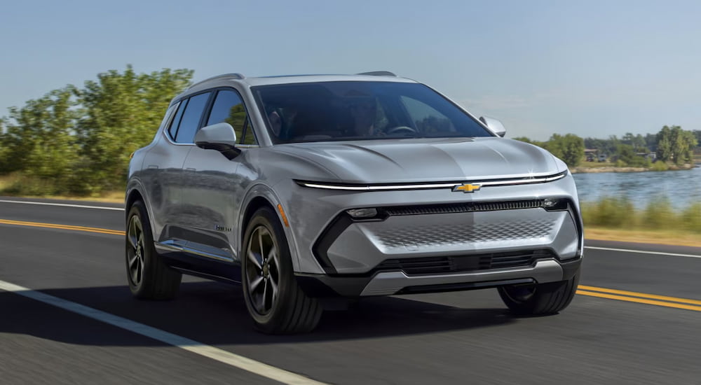 A grey 2025 Chevy Equinox EV for sale driving and facing right.