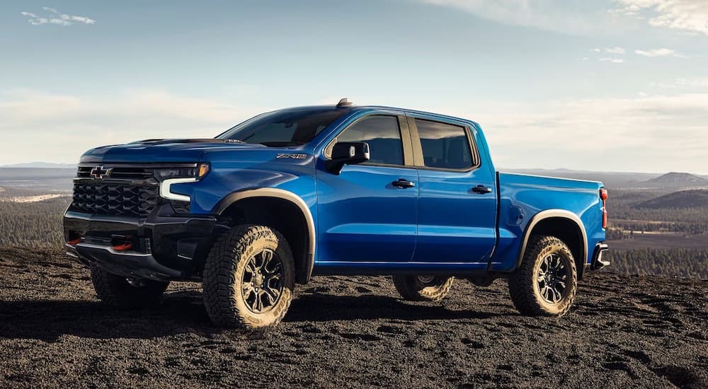 A blue 2024 Chevy Silverado 1500 ZR2 parked off-road and angled left after visiting a Chevy dealer near Taylor.