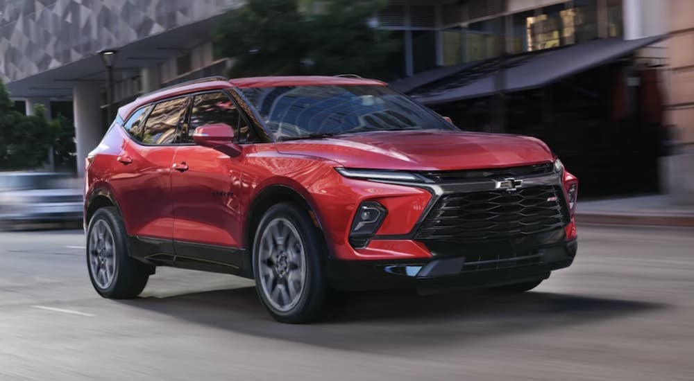 A red 2023 Chevy Blazer driving in a city.