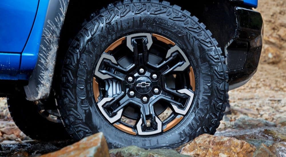 A close up shows the black wheel on a blue 2022 Chevy Silverado ZR2.