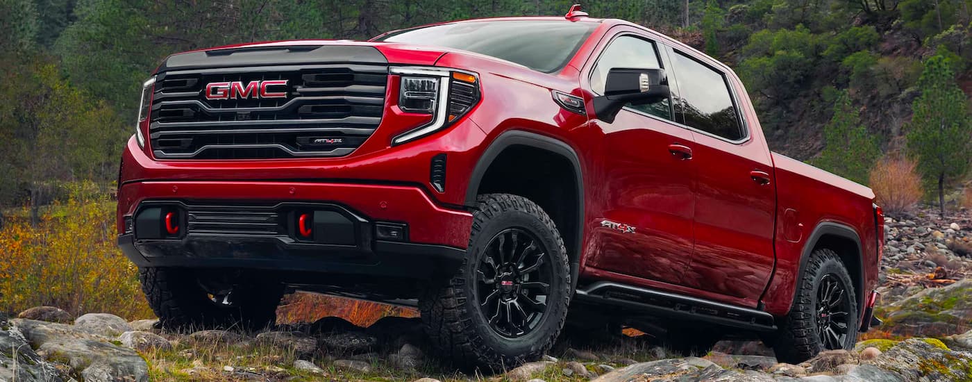 A red 2023 GMC Sierra 1500 AT4X parked off-road.