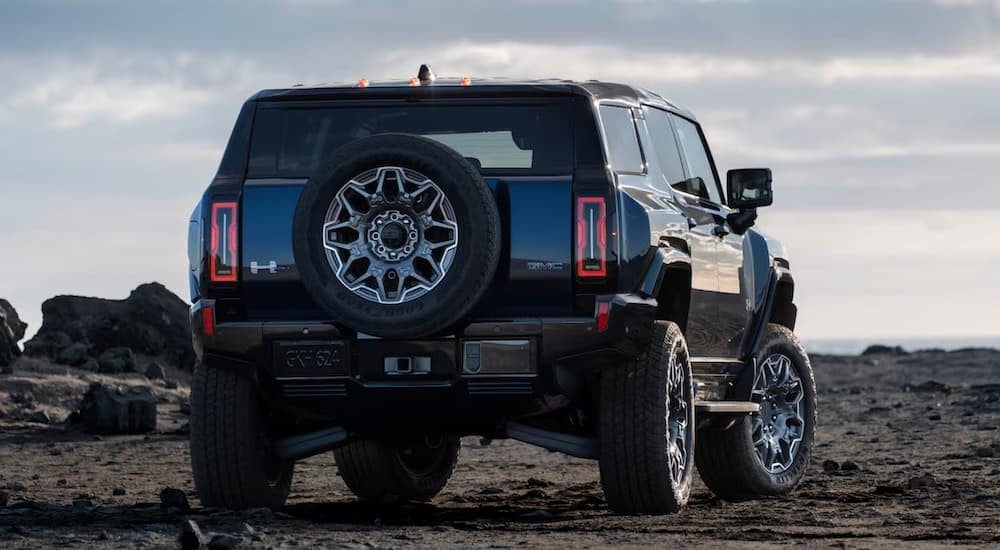 A black 2025 GMC Hummer EV SUV parked off-road.
