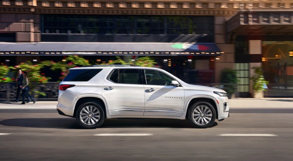 White 2023 Chevy Traverse driving in a city
