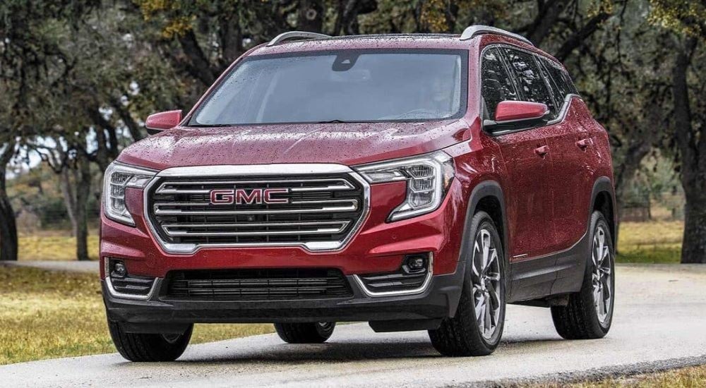 A red 2024 GMC Terrain SLT is shown driving.