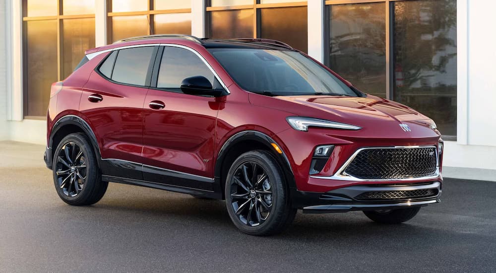 A red 2025 Buick Encore GX parked outside a building and angled right.