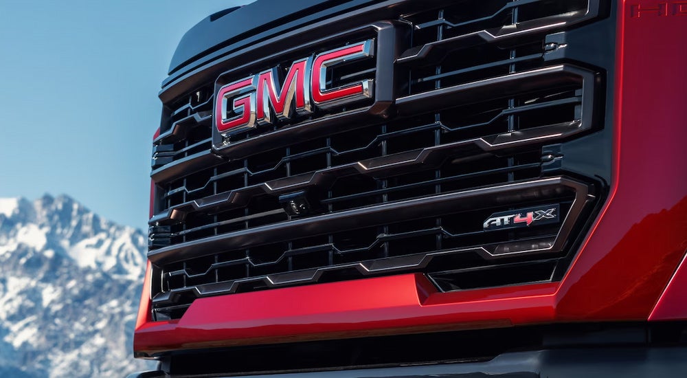 A close-up of the grille on a red 2024 GMC Sierra 3500 HD AT4X.